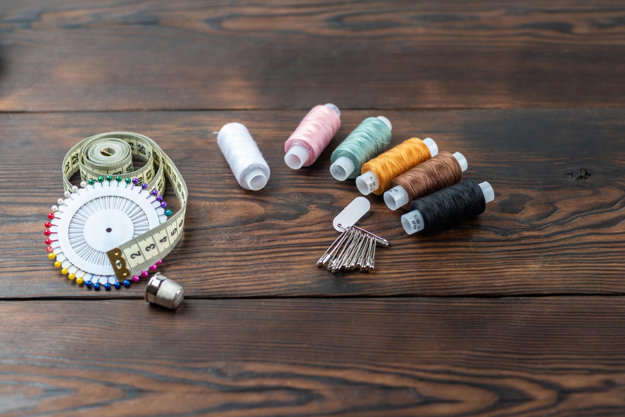 Workshop table with threads, needles and finished embroidery